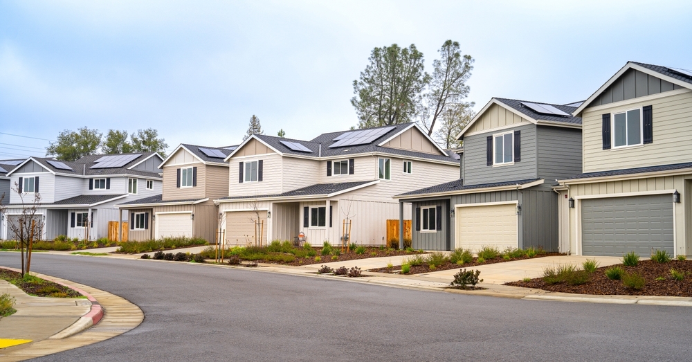 Street view of a row of modern two-story suburban single-family homes.